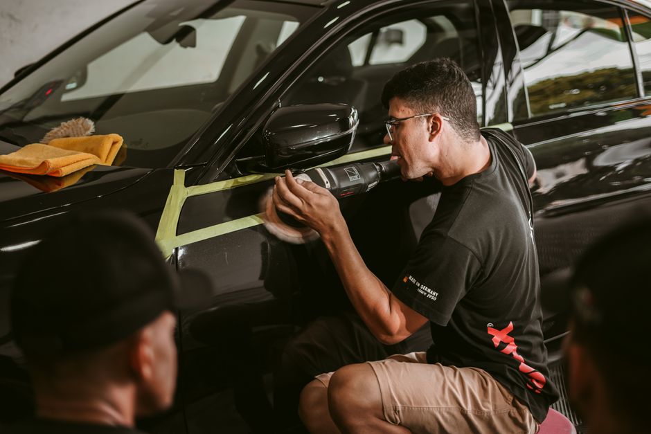 Professional auto detailer carefully polishing a vehicle's exterior