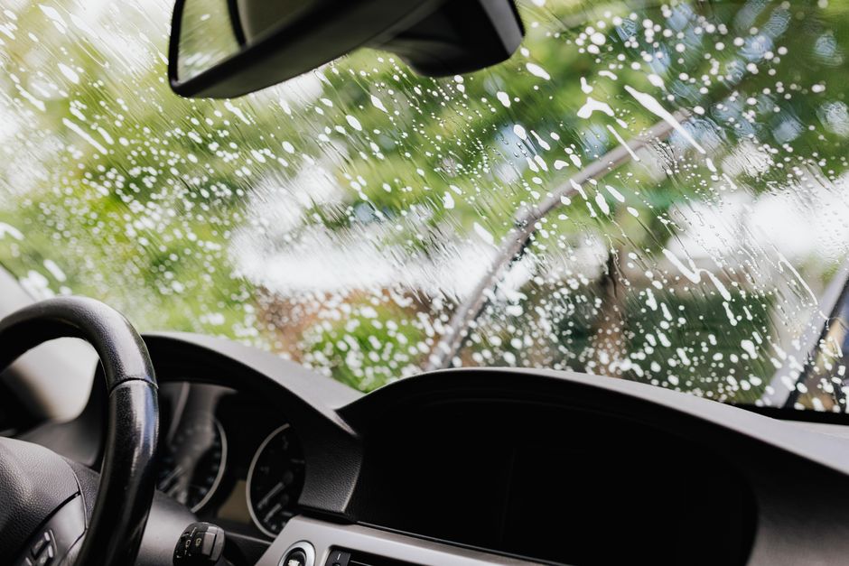 Detailing specialist meticulously cleaning the interior dashboard and steering wheel